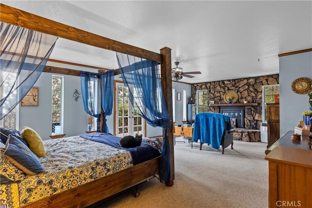 carpeted bedroom featuring a fireplace and ceiling fan