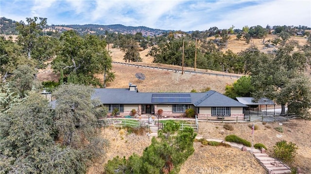 back of property featuring a mountain view and solar panels