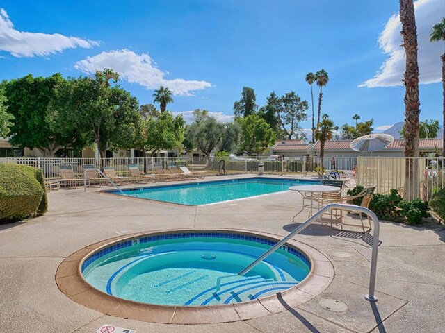 view of swimming pool with a hot tub and a patio area