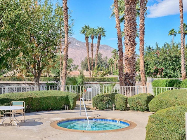 view of pool featuring a mountain view, a community hot tub, and a patio area