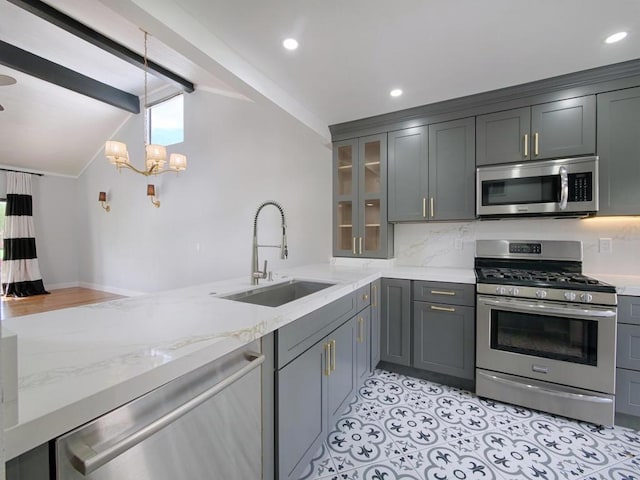 kitchen with appliances with stainless steel finishes, sink, vaulted ceiling with beams, and gray cabinetry