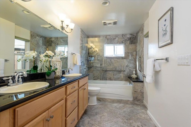 full bathroom with toilet, vanity, and tiled shower / bath