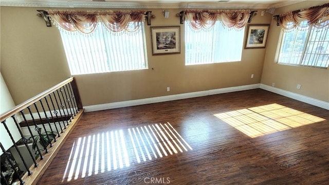 empty room with plenty of natural light and dark hardwood / wood-style flooring