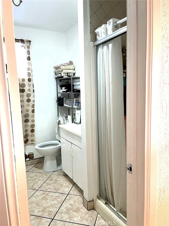 bathroom with toilet, vanity, tile patterned floors, and walk in shower