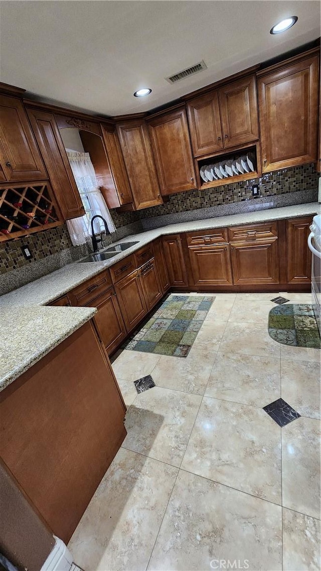 kitchen featuring light stone counters and sink