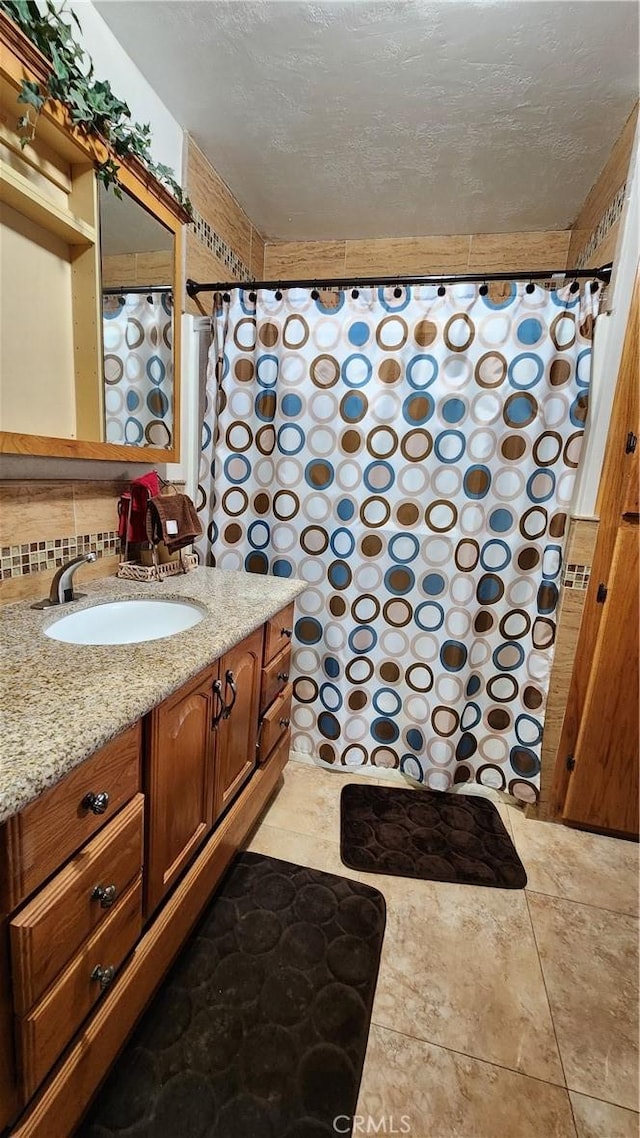 bathroom featuring a shower with shower curtain, tasteful backsplash, and vanity