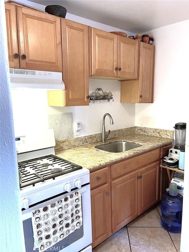 kitchen featuring light tile patterned floors, sink, and white gas stove