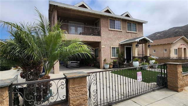 view of front of house with a mountain view and a balcony