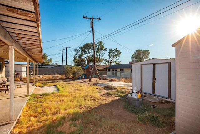 view of yard featuring a playground and a storage unit