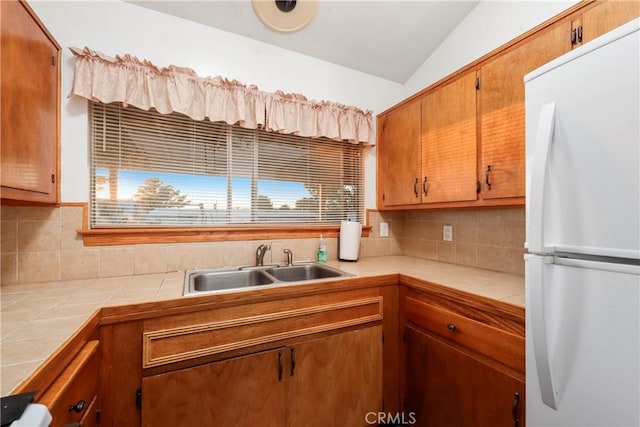 kitchen featuring tile counters, white refrigerator, and decorative backsplash