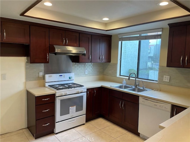 kitchen featuring tasteful backsplash, sink, light tile patterned floors, and white appliances