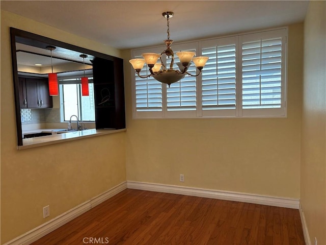 unfurnished dining area with a chandelier, wood-type flooring, and sink