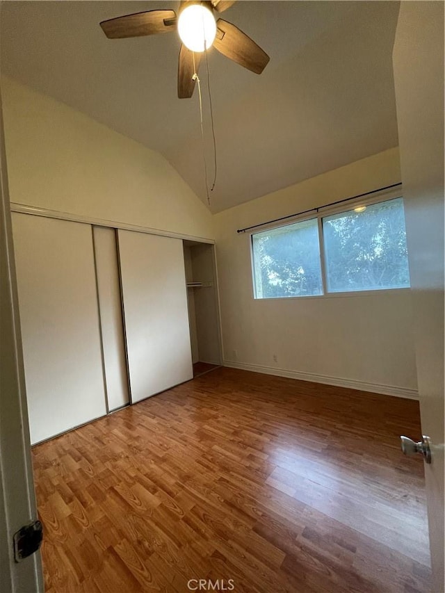 unfurnished bedroom with hardwood / wood-style floors, ceiling fan, and lofted ceiling