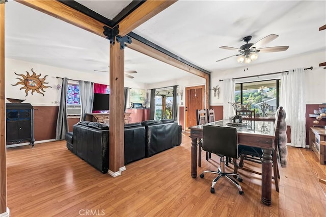 dining space featuring beamed ceiling, light wood-type flooring, and ceiling fan