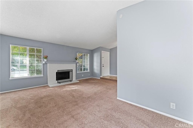 unfurnished living room featuring carpet flooring and a fireplace