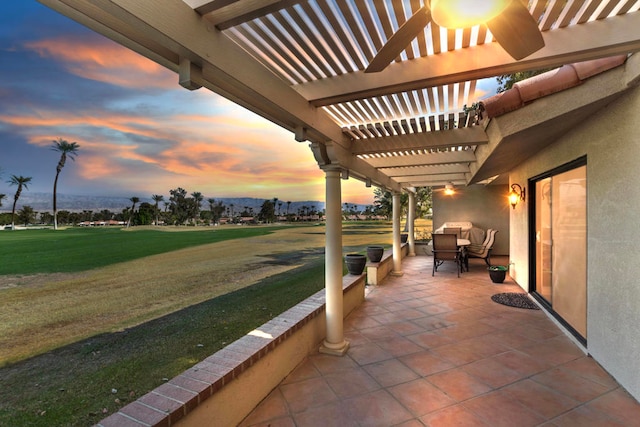 patio terrace at dusk with a yard and a pergola