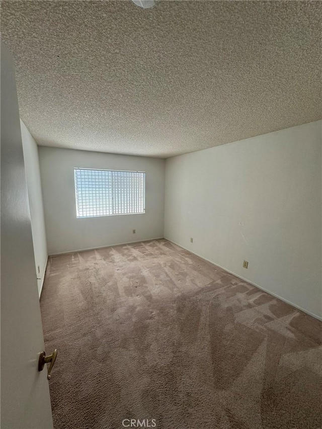 empty room featuring carpet flooring and a textured ceiling