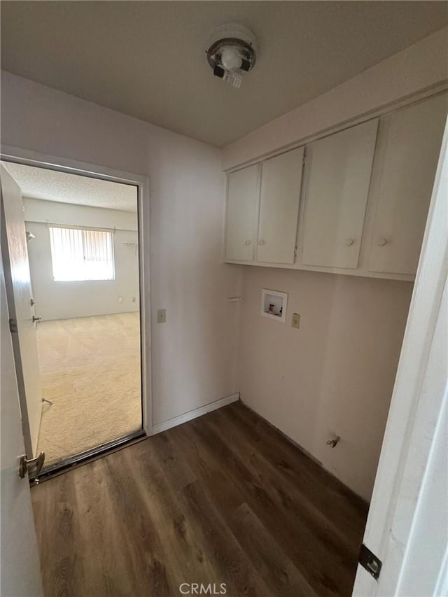 clothes washing area featuring cabinets, washer hookup, and dark hardwood / wood-style floors