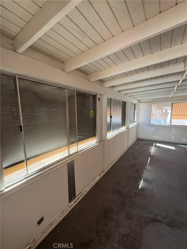 unfurnished sunroom featuring beam ceiling and wood ceiling