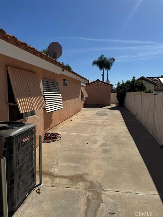 view of patio / terrace with a shed and cooling unit