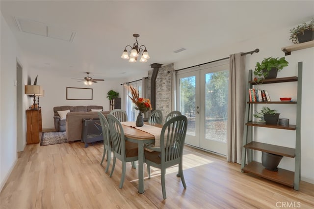 dining room with french doors, light hardwood / wood-style flooring, and ceiling fan with notable chandelier