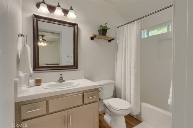 full bathroom featuring hardwood / wood-style floors, toilet, ceiling fan, vanity, and shower / tub combo with curtain