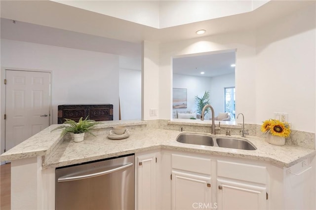 kitchen with sink, white cabinetry, light stone counters, stainless steel dishwasher, and kitchen peninsula