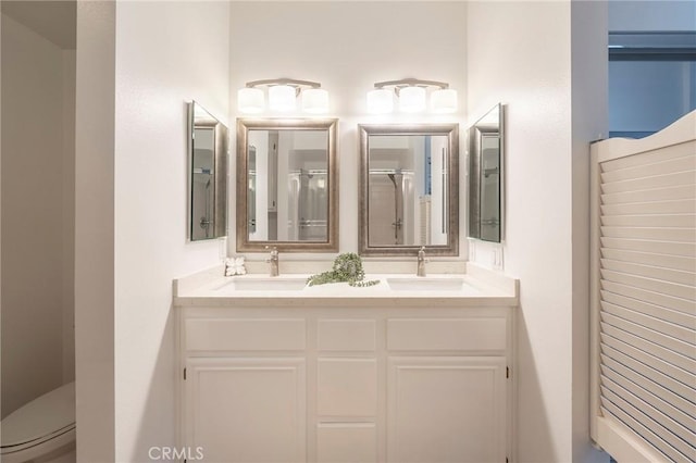 bathroom featuring vanity, a shower with shower door, and toilet