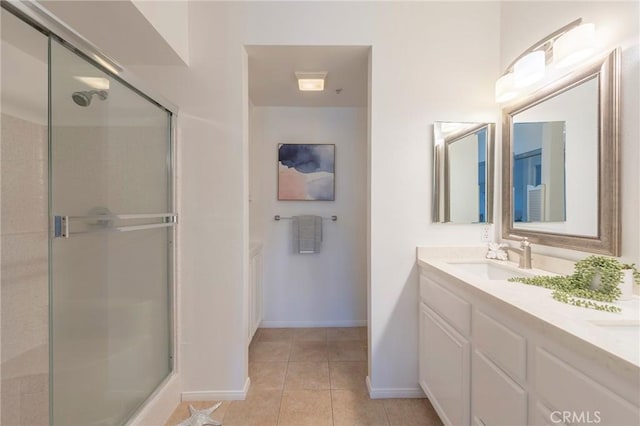 bathroom featuring tile patterned flooring, vanity, and a shower with door