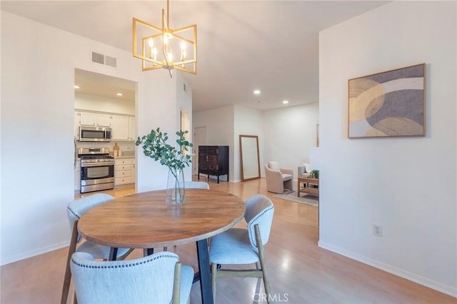 dining room featuring an inviting chandelier and light hardwood / wood-style flooring