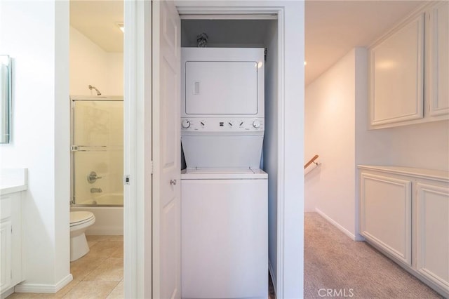 washroom with stacked washer and clothes dryer and light tile patterned floors