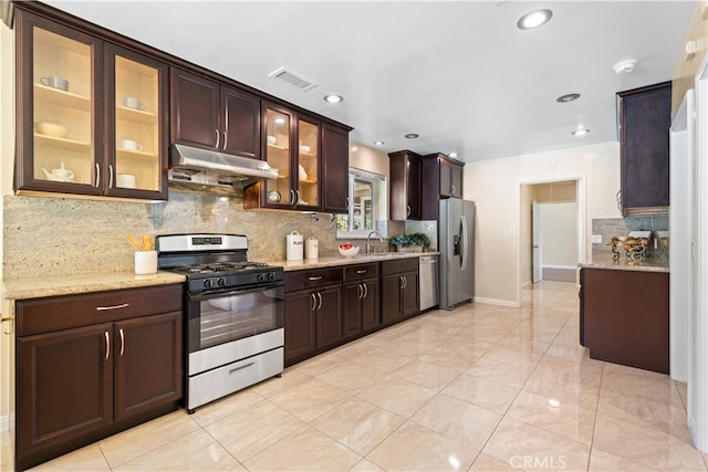 kitchen featuring sink, light stone countertops, stainless steel appliances, and tasteful backsplash