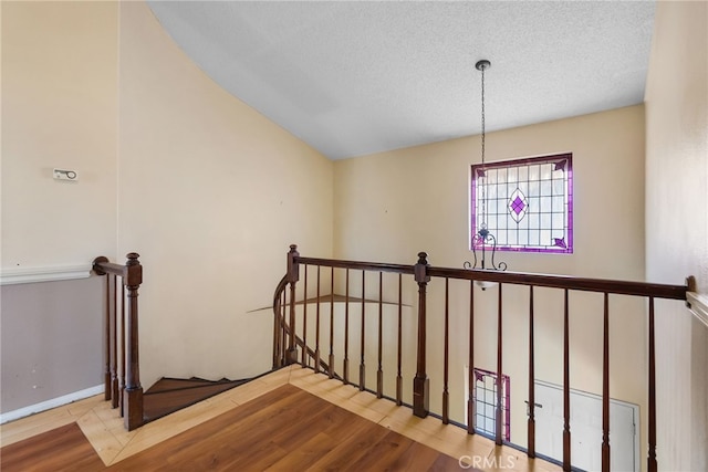 staircase featuring wood-type flooring and a textured ceiling