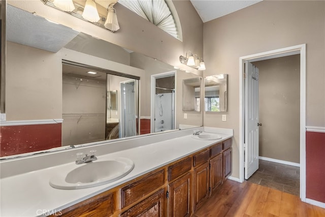 bathroom with hardwood / wood-style flooring, vanity, a healthy amount of sunlight, and a textured ceiling