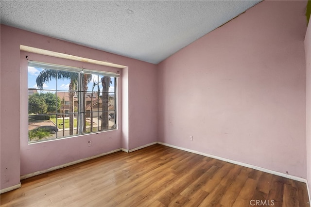 unfurnished room featuring a textured ceiling and light hardwood / wood-style floors