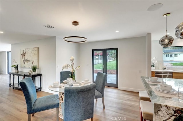 dining space featuring light hardwood / wood-style flooring and french doors