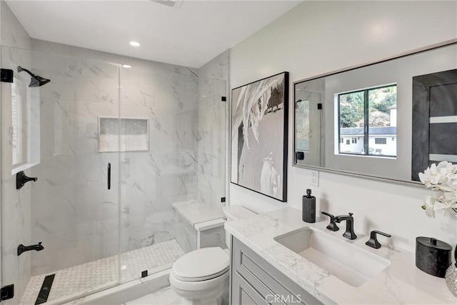 bathroom featuring vanity, toilet, and a shower with shower door