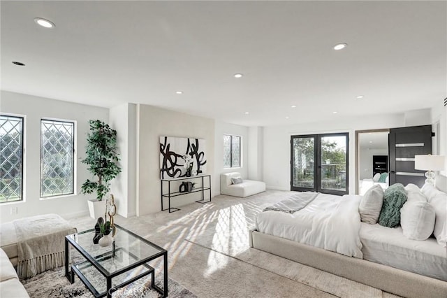 bedroom featuring multiple windows, french doors, and light colored carpet