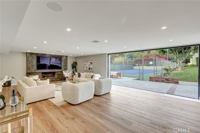 living room featuring light hardwood / wood-style flooring and a wall of windows