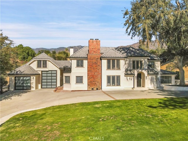 back of property with a lawn and a mountain view