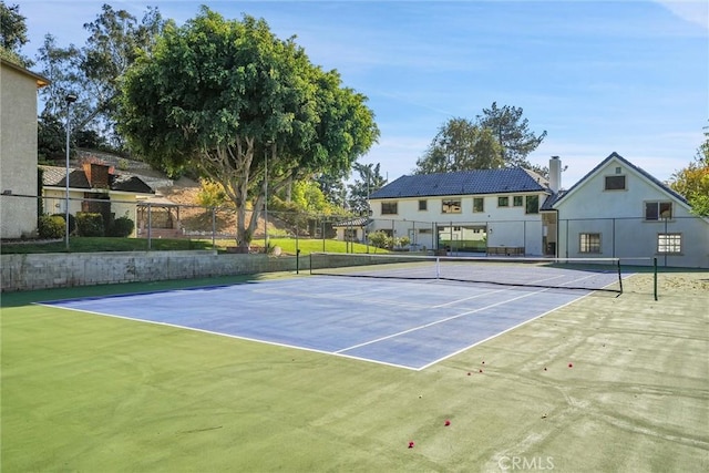 view of tennis court featuring basketball hoop