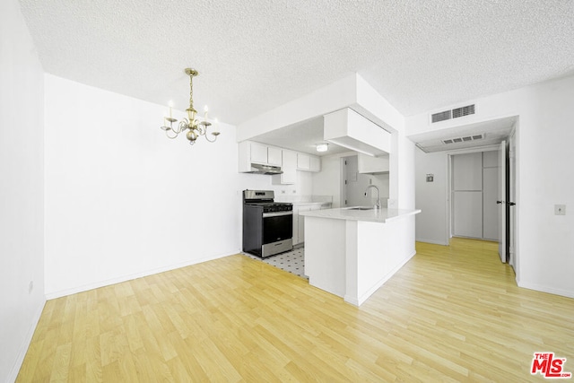 kitchen with white cabinets, stainless steel stove, light hardwood / wood-style flooring, and sink