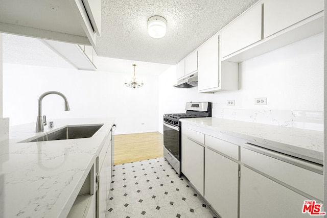 kitchen with stainless steel gas range, sink, decorative light fixtures, a notable chandelier, and white cabinetry