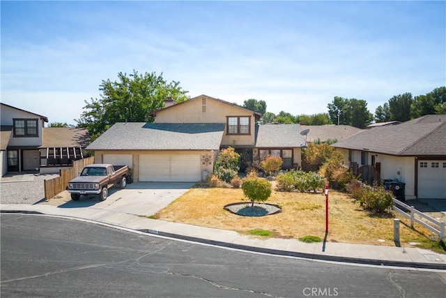 view of front of house featuring concrete driveway, an attached garage, fence, and stucco siding