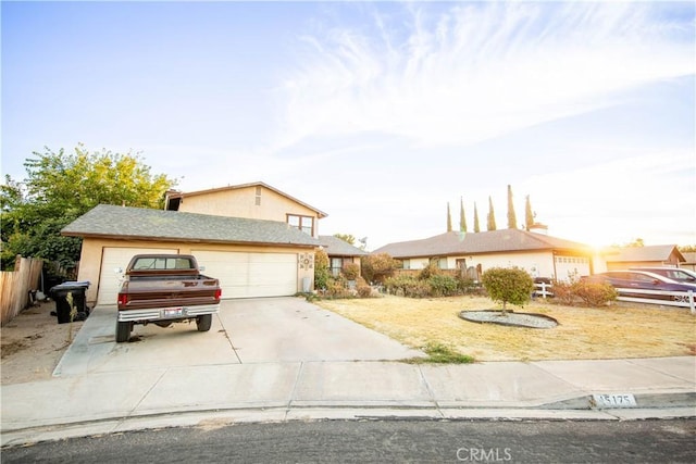 view of front of house featuring a garage, concrete driveway, fence, and stucco siding