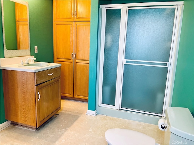 bathroom featuring vanity, tile patterned floors, toilet, and an enclosed shower