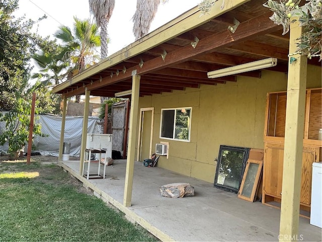 view of patio / terrace with a wall mounted air conditioner and washer / clothes dryer