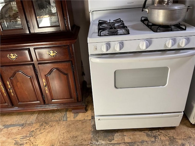 interior details featuring dark brown cabinetry and white gas range