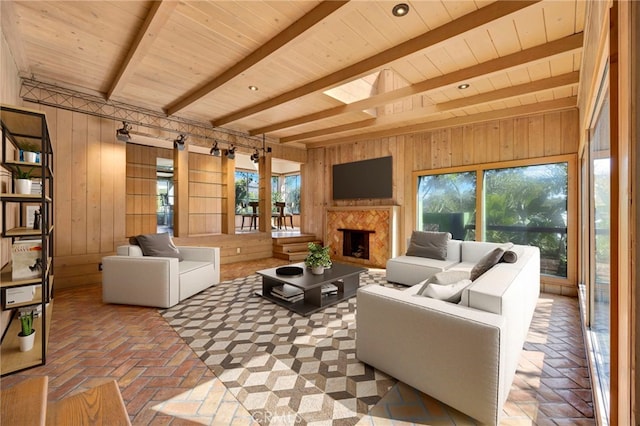 living room featuring a premium fireplace, beamed ceiling, wood ceiling, and wood walls