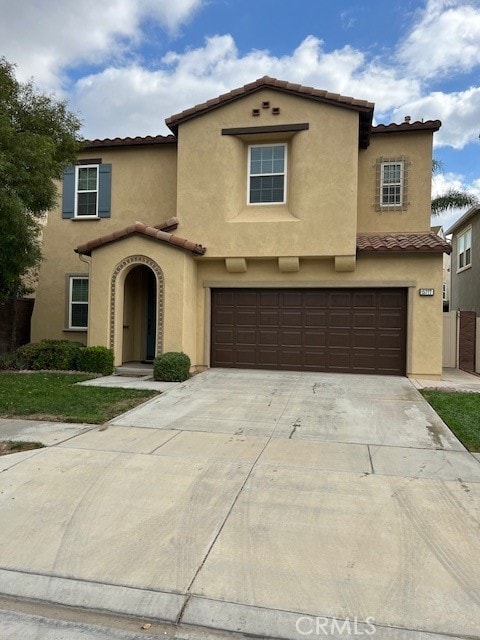 mediterranean / spanish-style house with a garage